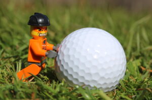 Angry Lego man pushing a golf ball